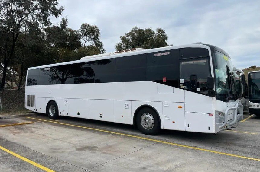 A white bus is parked on the side of the road.