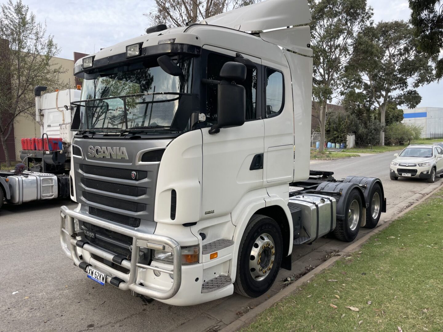 A white truck parked on the side of a road.