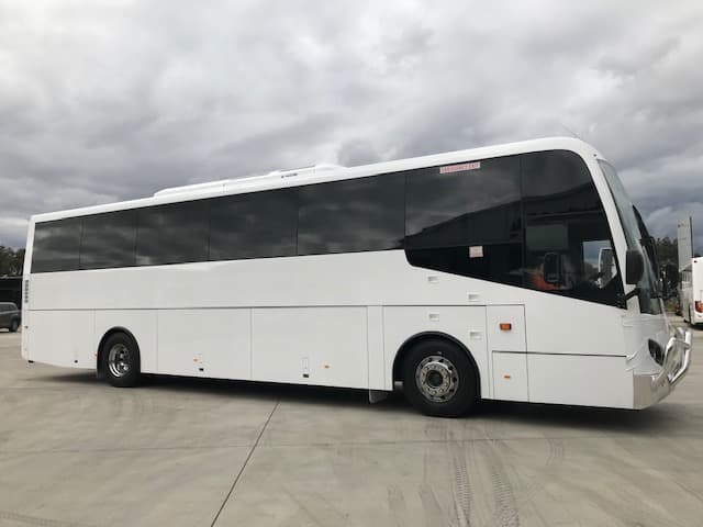 A white bus is parked on the side of the road.